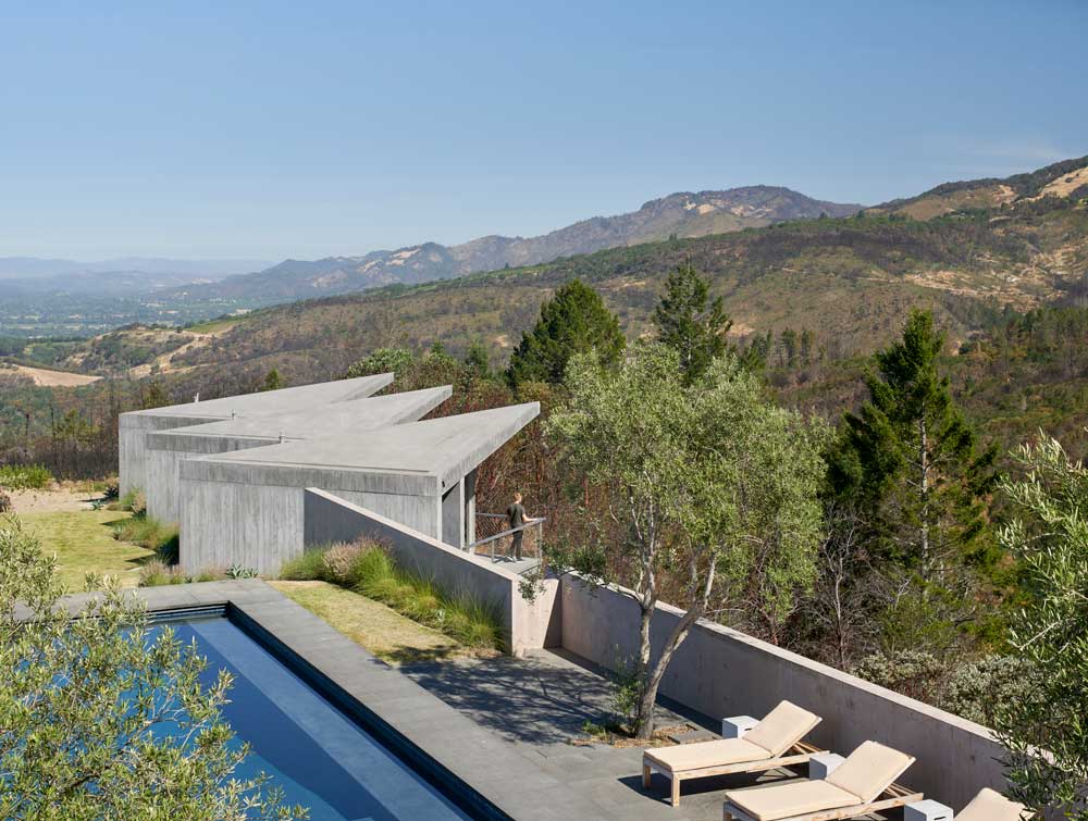 The board-formed concrete exterior gives a feeling of stability and rhythm, so from the back, the volumes, which are twisted so as to maximize each view, appear to emerge from the earth even as, from the ridge, they seem to float.