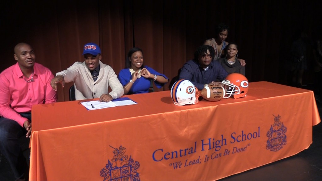 Central High School football players Derrick Evans (left) and Chandler King (right) sign scholarships to play at Carson-Newman University and Benedict College respectively.