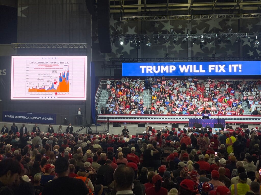 Trump, on stage in Macon, shows immigration chart.
