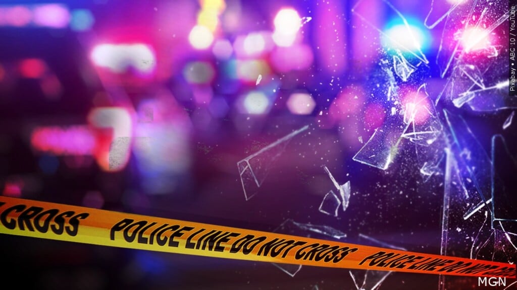 Broken glass and crime scene tape with emergency lights representing fatal I-75 crash in Monroe County
