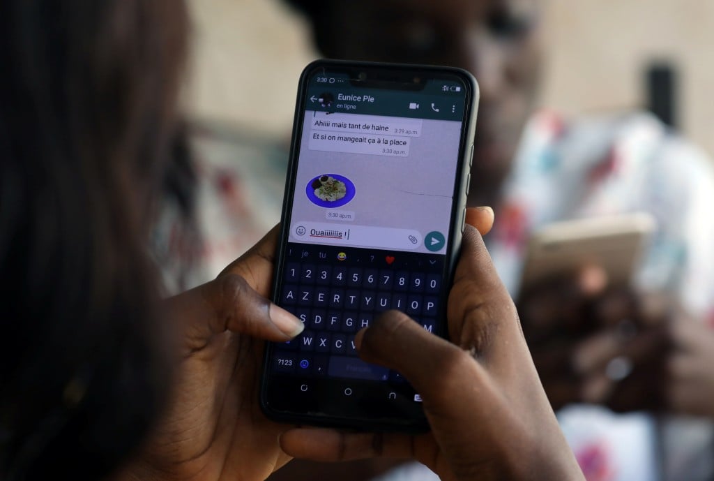 A Woman Uses Zouzoukwa Emojis While Chatting On Mobile Phone In Abidjan