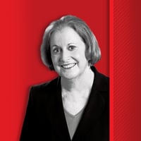 susan percy smiling at camera with red background