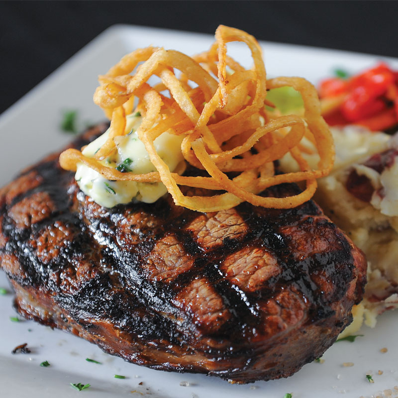Quality Ingredients: The 16-ounce ribeye with crisp onion rings, garlic herb butter and asparagus spears