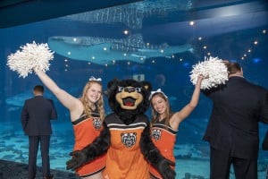 Two Cheerleaders In Orange Uniforms Iwht Pompoms And The Mascot Dot He Bear From Mercer University At 40 Under 40 Event