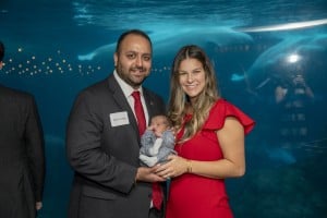 Couple Holding Award At Event Women In Red Dress And Man In Suit With Red Tie Smiling