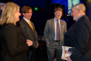 Lori Geary, Announder, Ben Young, Publisher and 2023 Georigan of the Year Pat Wilson speaking with someone and laughing