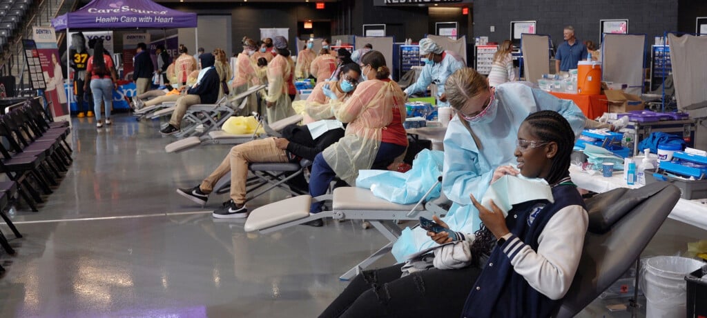 Picture of several people getting dentail care at an event with TeamSmile and CareSource