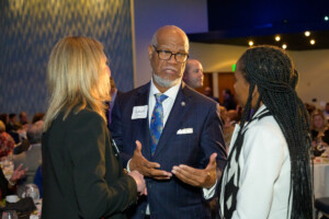Hall of Fame Inductee Calviin Smyre talking with two woment not looking at the camera