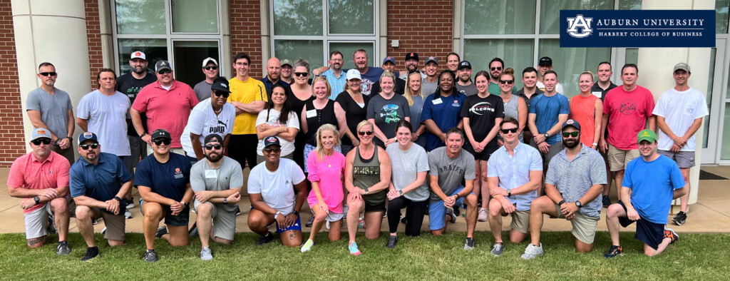 Auburn's EMBA 2024 Class adult students standing on law
