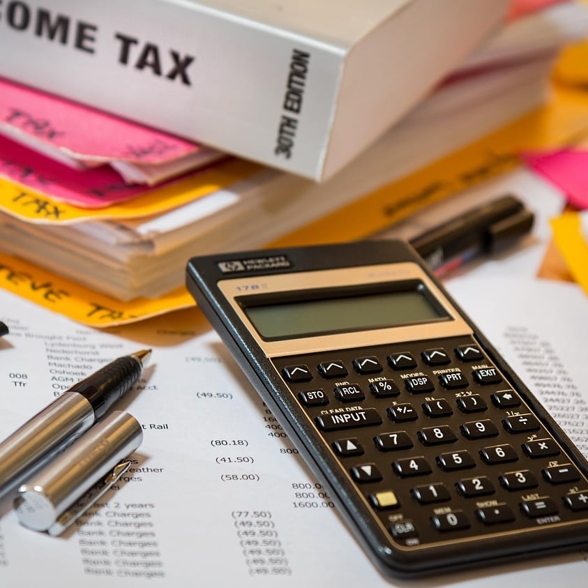 Calculator with income tax book and pen