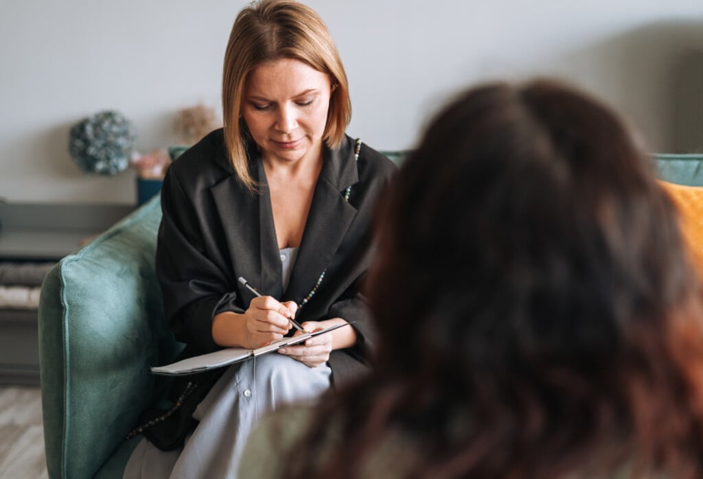 Young Woman Talking To Psychologist In The Office