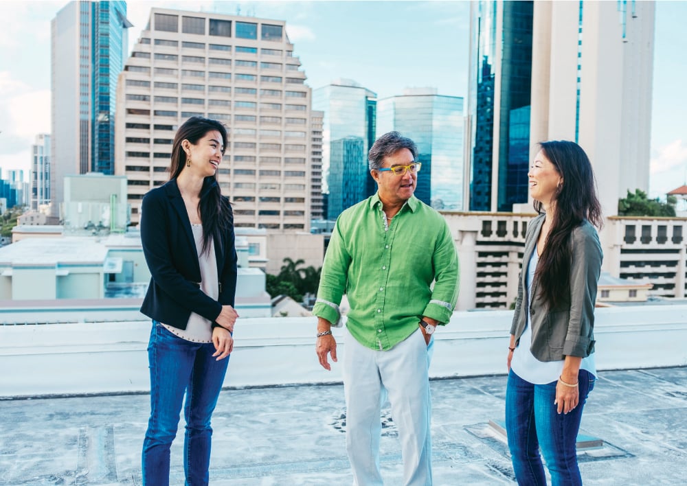 Guy Akasaki, CEO of Commercial Roofing and Waterproofing Hawaii Inc., and his daughters, Candace and Dana, on one of the roofs the company installed. He wants them to take over someday – if they want to, and if they’re ready. Photo: David Croxford and Aaron K. Yoshino. 