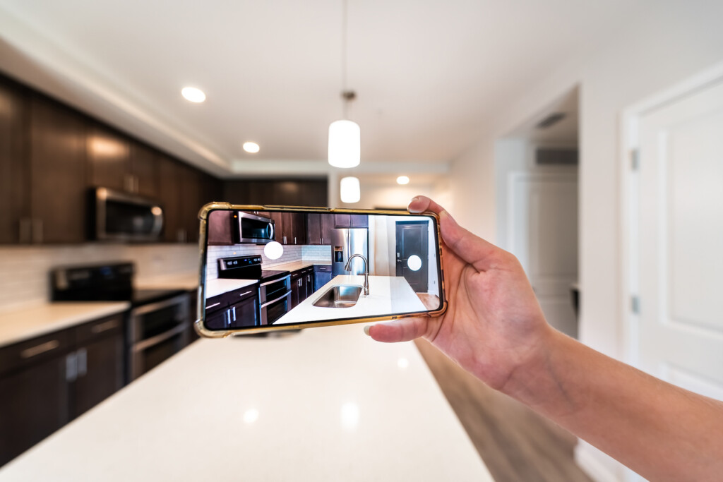 Hand Photographing House Apartment Kitchen Island Room For Sale Or Rent With Phone Smartphone Closeup Point Of View In Modern Luxury Condo Home Tour With Blurry Bokeh Background