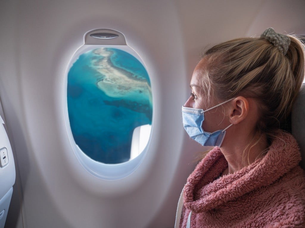 Woman Traveling By Plane During Coronavirus Pandemic