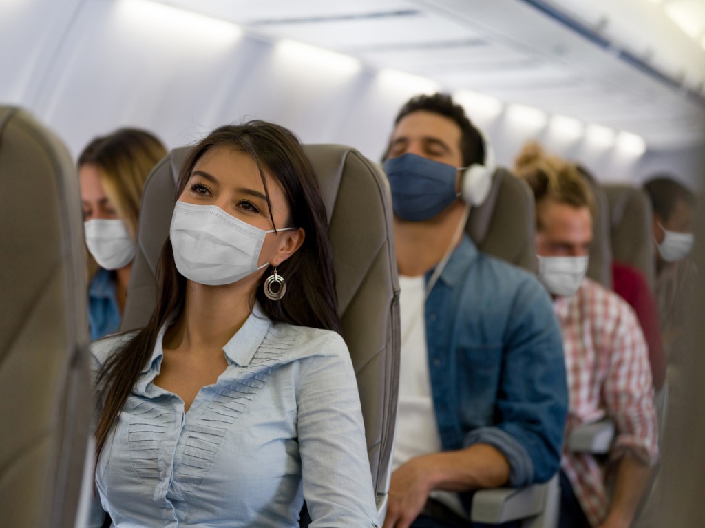 Woman Traveling By Plane Wearing A Facemask