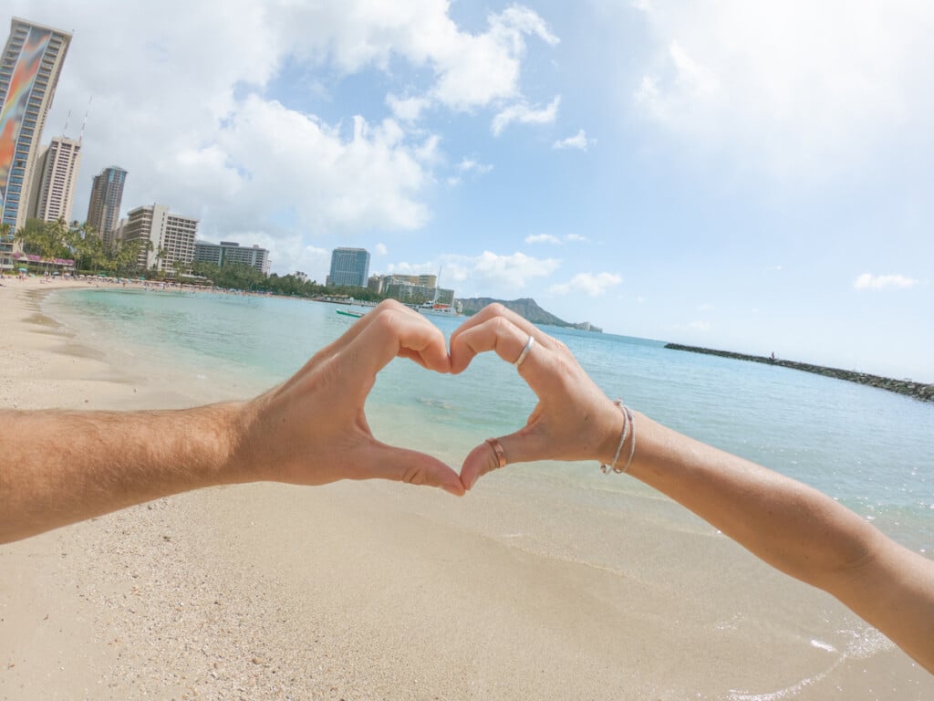 Close Up Of Couple On Waikiki Beach Making A Heart Shape Finger Frame Together