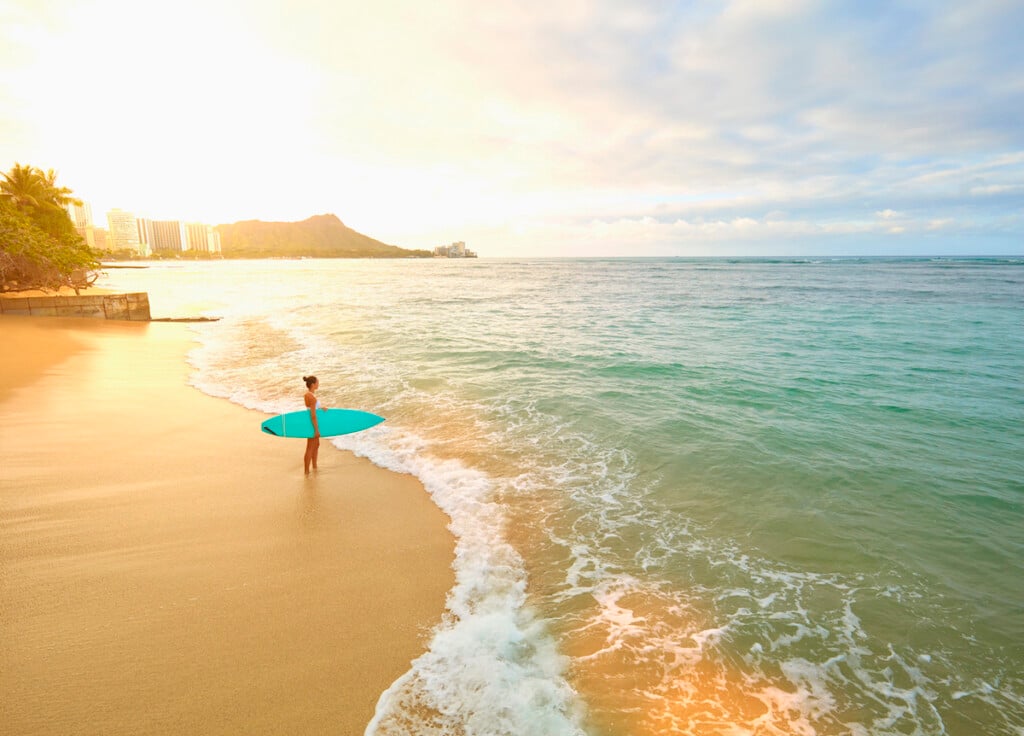 Pacific Islander Woman Holding Surfboard On Beach