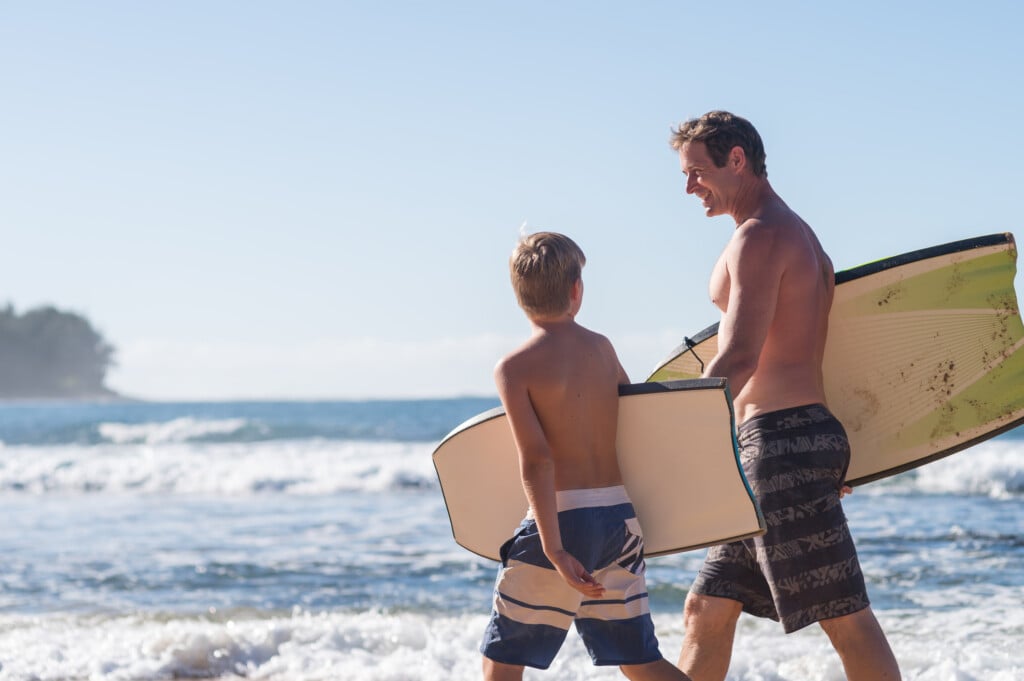 Dad Giving His Son A Boogie Boarding Lesson