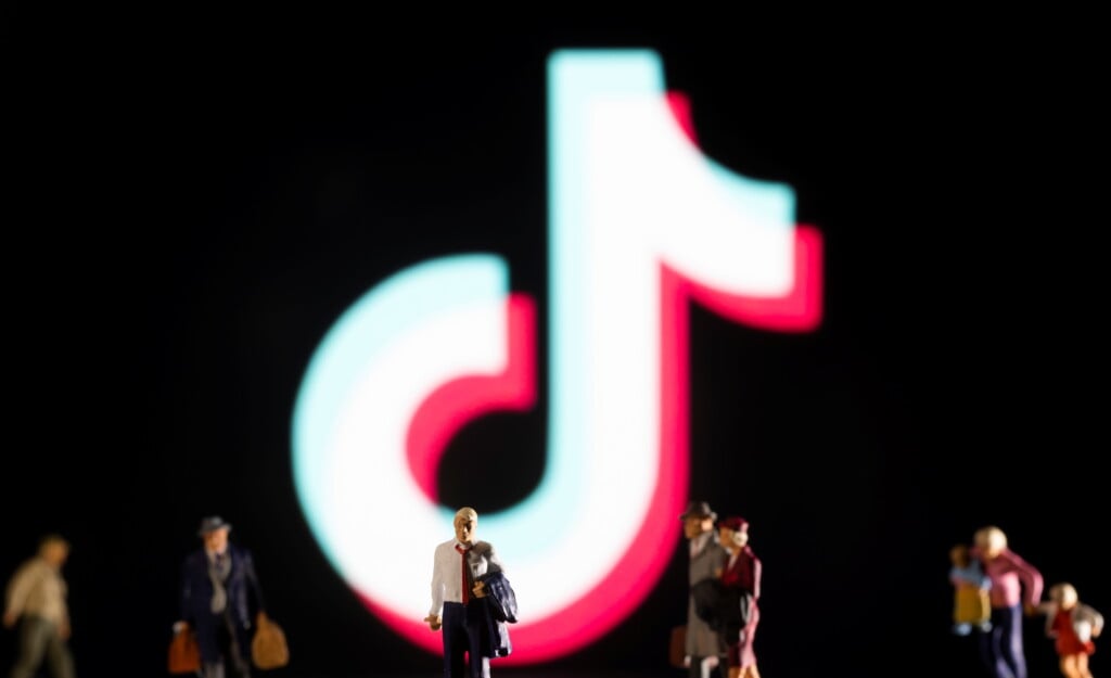 Illustration Shows Small Figurines And Displayed Tik Tok Logo