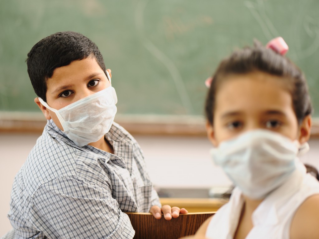 students in a classroom wearing masks (Source: Stockblocks)