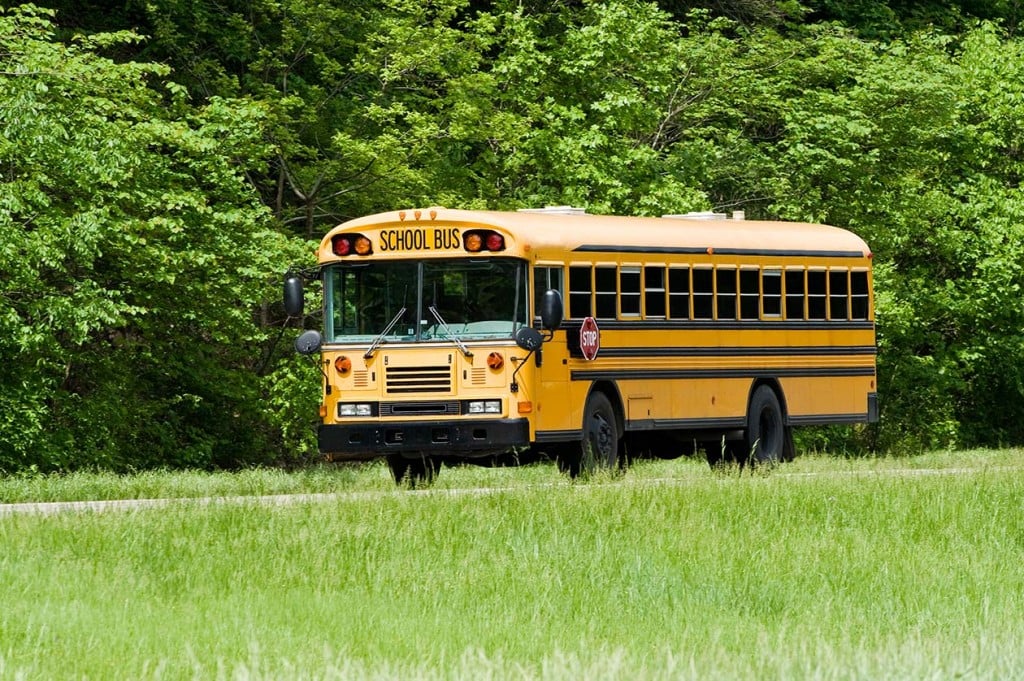 School bus traveling on interstate n springtime (Source: Storyblocks)