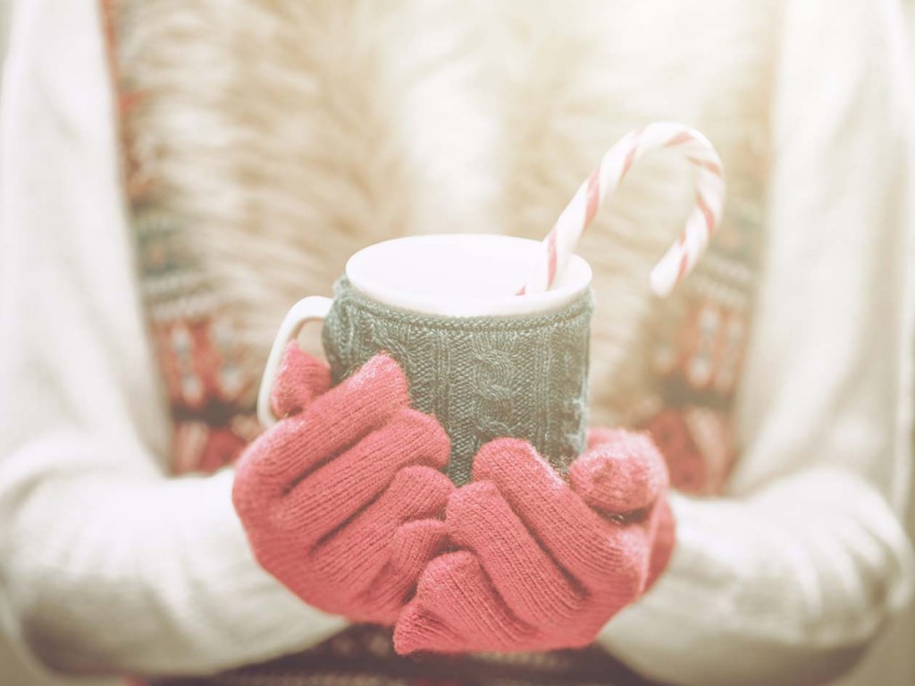 Woman Holding Winter Cup Close Up On Light Background Woman Hands In Woolen Red Gloves (Source: Storyblocks)
