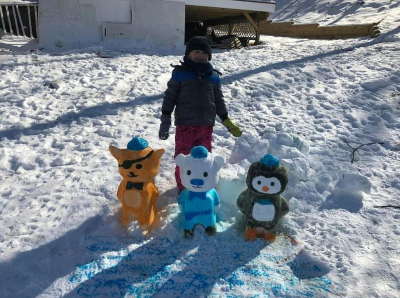 Gabriel Primeau-White shows off his family's snow sculpture of characters from the Octonauts cartoon.
