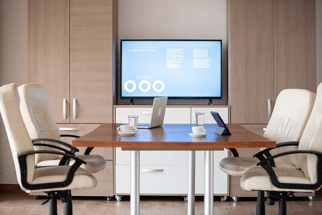 empty business meeting conference room with graphs and diagrams on TV (Source: Storyblocks)