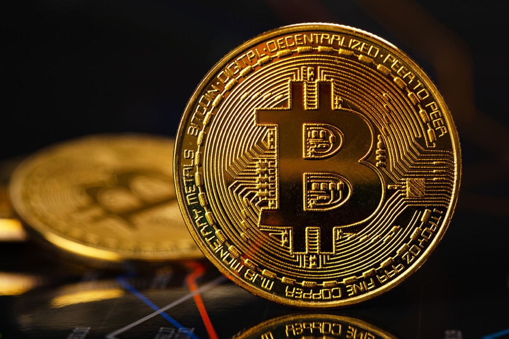 gold Bitcoin standing on financial charts for cryptocurrency prices (Source: Storyblocks)