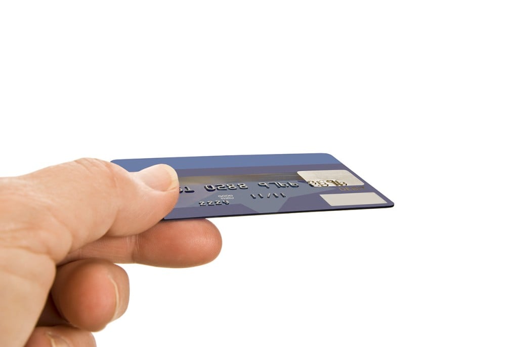 hand offering debit or credit card (Source: Storyblocks)