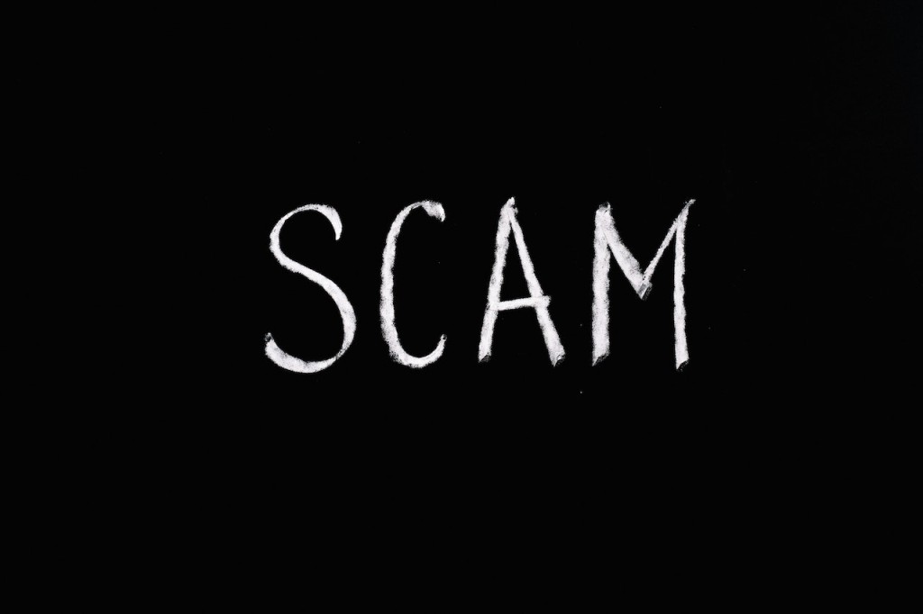 White words saying scam on black background (Source: Pexels/Anna Tarazevich)
