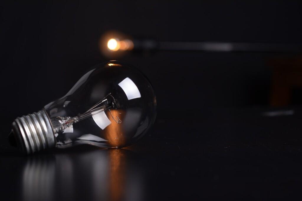 Clear Filament Bulb on Black Pad (Source: Pexels/Pixabay)