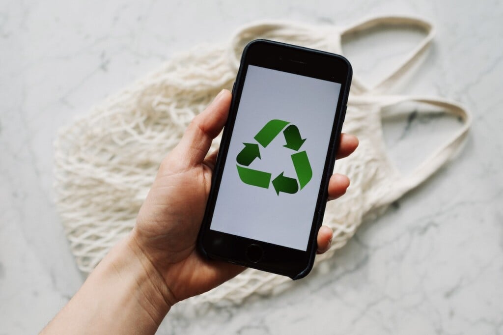 hand holding smartphone with recycle symbol (Source: Pexels/ready made)