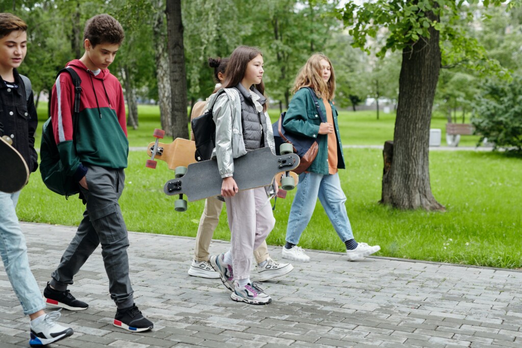 students walking on a sidewalk (Source: Pexels/Max Fischer)