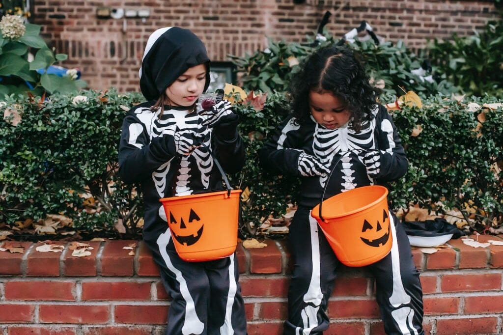 Two kids dressed up as skeletons trick-or-treating. (Source: Charles Parker)