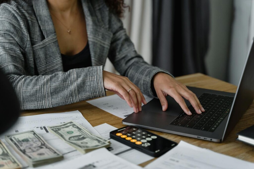 woman in plaid blazer using laptop (Source: Pexels/Tima Miroshnichenko)