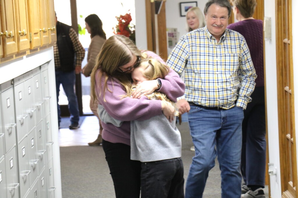 CRC Spelling Bee champion Clara Wilkerson embraces her mother, Carey, on Wednesday, Feb. 28, at Fox Radio Network as owner Steve Fuchs passes by. (Source: Poplar Bluff R-I School District)