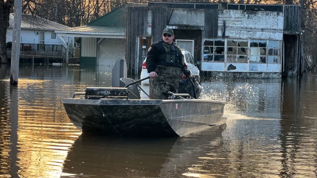 A man is in a boat in the flooded city of Rives, Tennessee