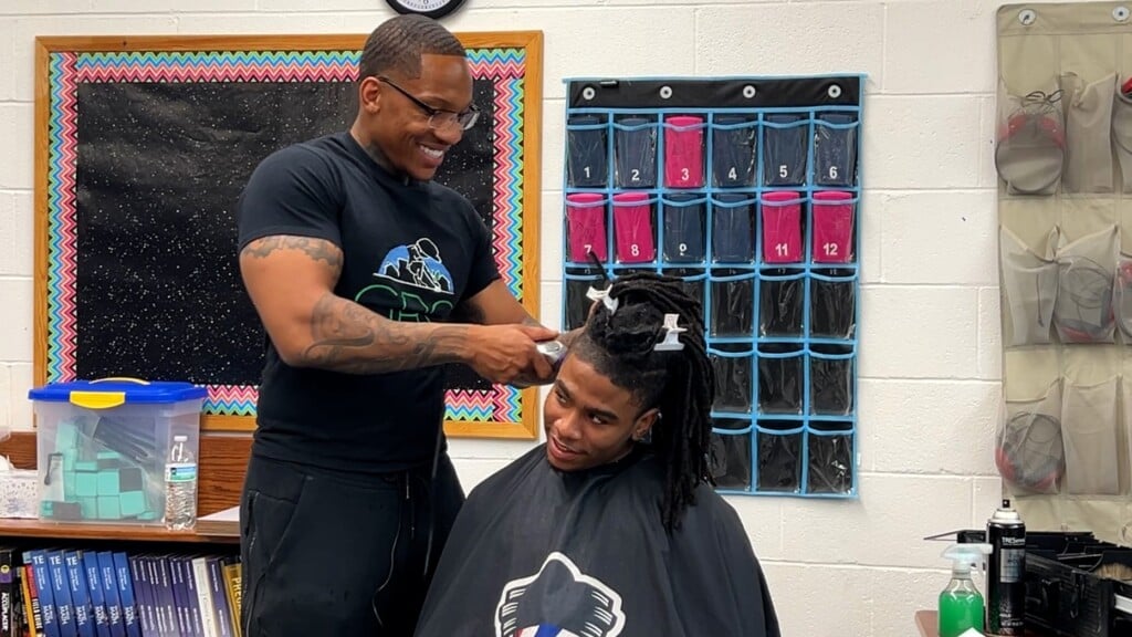 Dr. Ryan Reed cutting a student's hair at Meridian High School