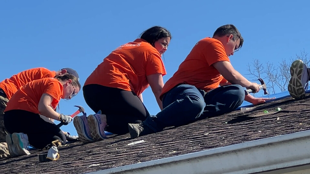 Samaritan's Purse volunteers putting a tarp on a roof damaged by a tornado.