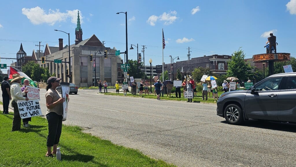 Demonstrators holding up signs at Hands off Iran Rally