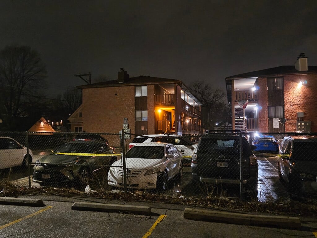 Crime scene tape is set up around some vehicles at an apartment complex near 22nd and G streets.