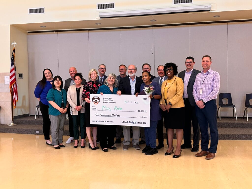 Mary Abebe stands with her $10,000 check and the Scottish Rite Organization.