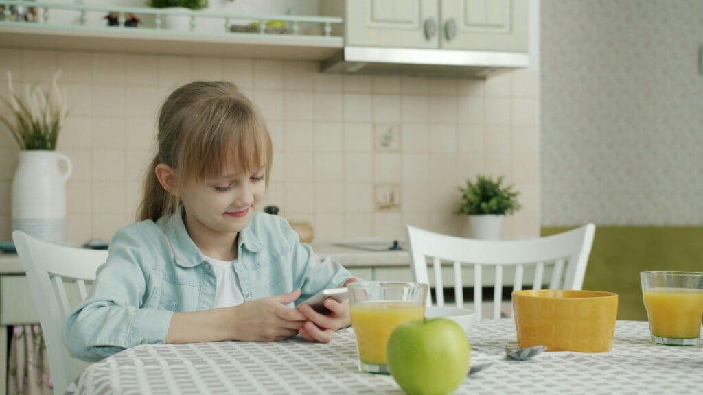 Kid on phone in kitchen