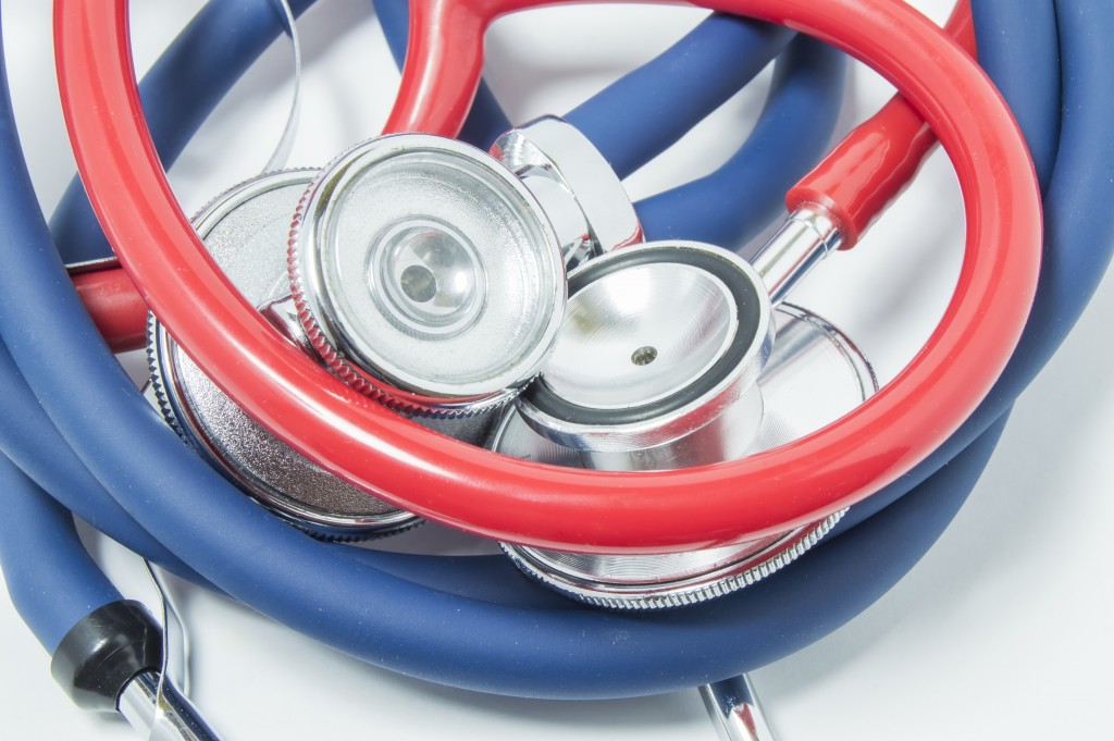 Red And Blue Stethoscopes Is Wound Into Ball. The Concept Of Photo That Symbolizes Hard Diagnosis, Difficulties Or Problems With Diagnostics Of Disease, As Well As Connection, Unity, Love In Medicine