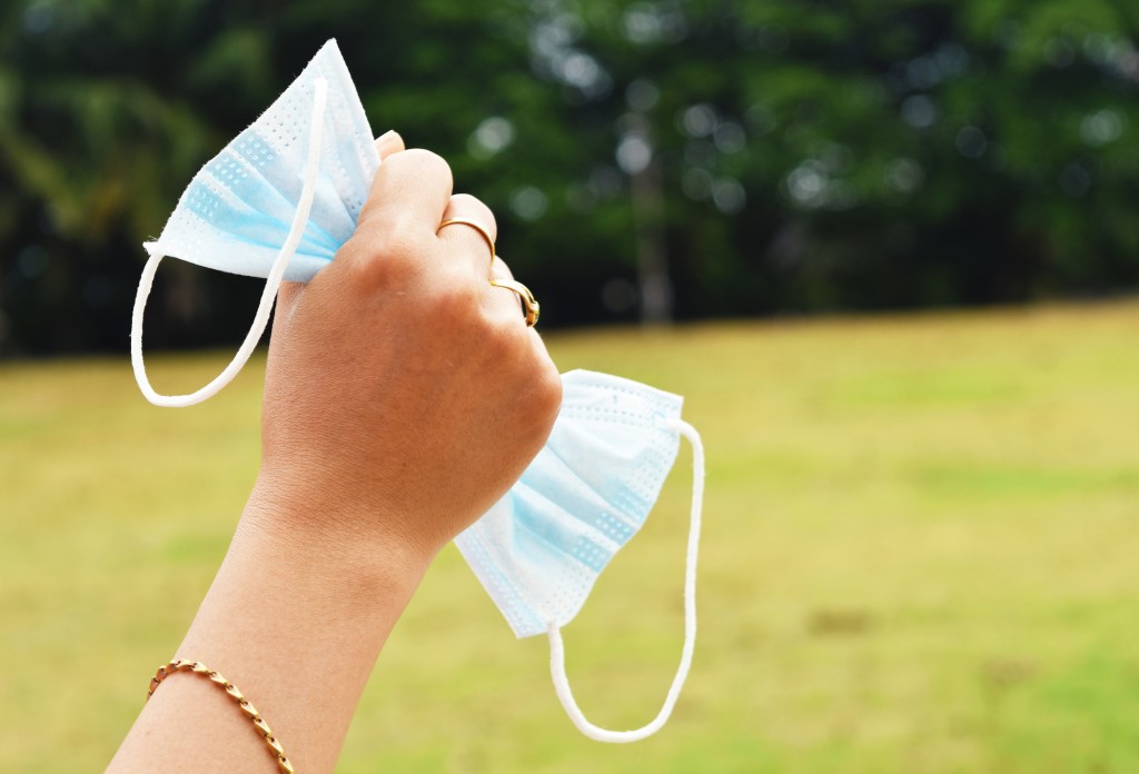 The End Of The Coronavirus Covid 19, The End Of Quarantine Concept With Hand Holding Used Medical Mask