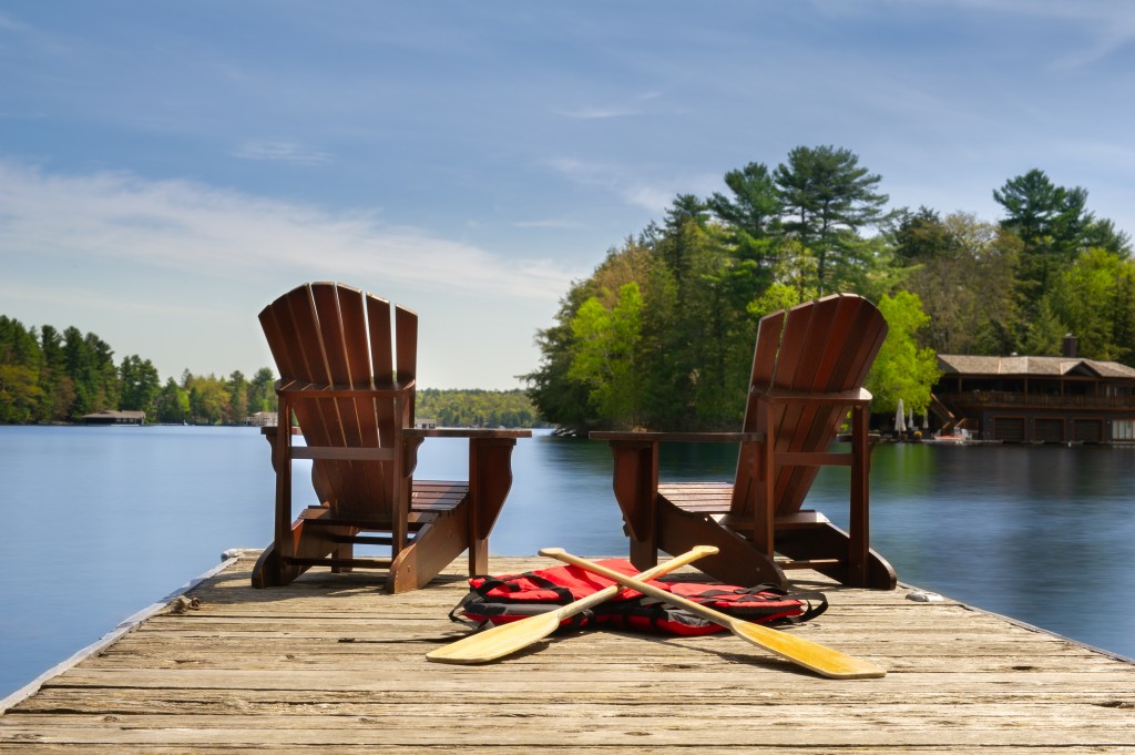 Adirondack Chairs On A Wooden Dock Facing Ta Calm Lake