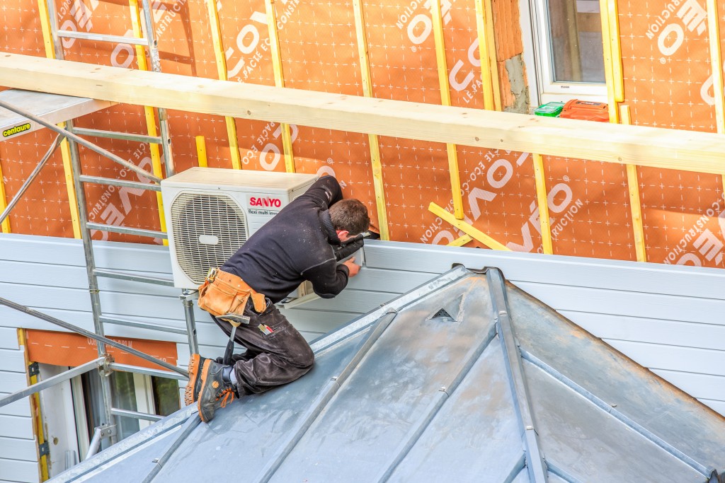 Worker Installing Insulation On The Wall Of A House