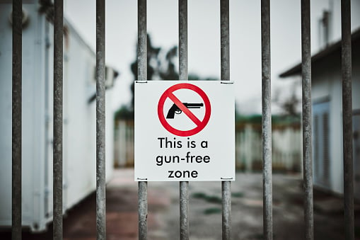 Shot Of A Sign On A Fence Saying “this Is A Gun Free Zone”
