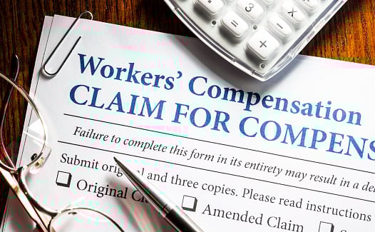 Workers' Compensation Form With Pen And Glasses